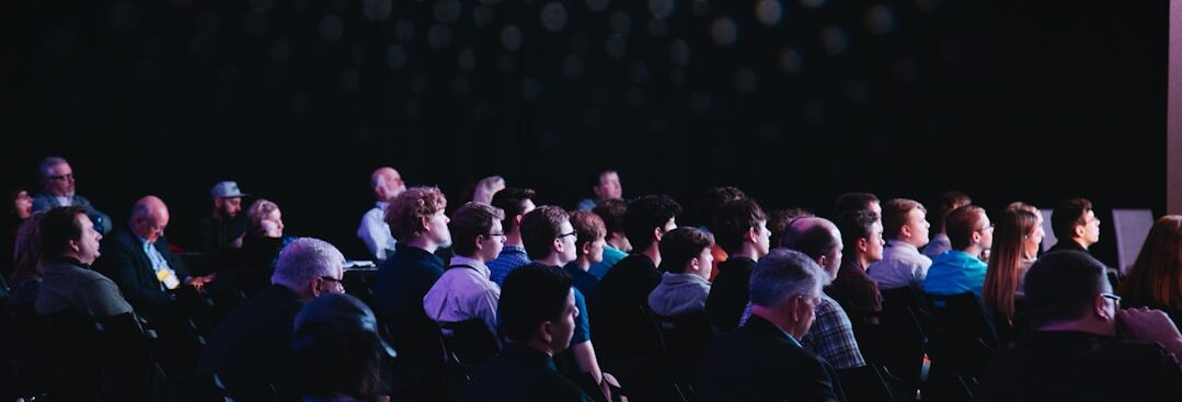 crowd of people sitting on chairs inside room